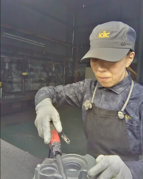 手袋を着用し工具で製品を加工している様子
